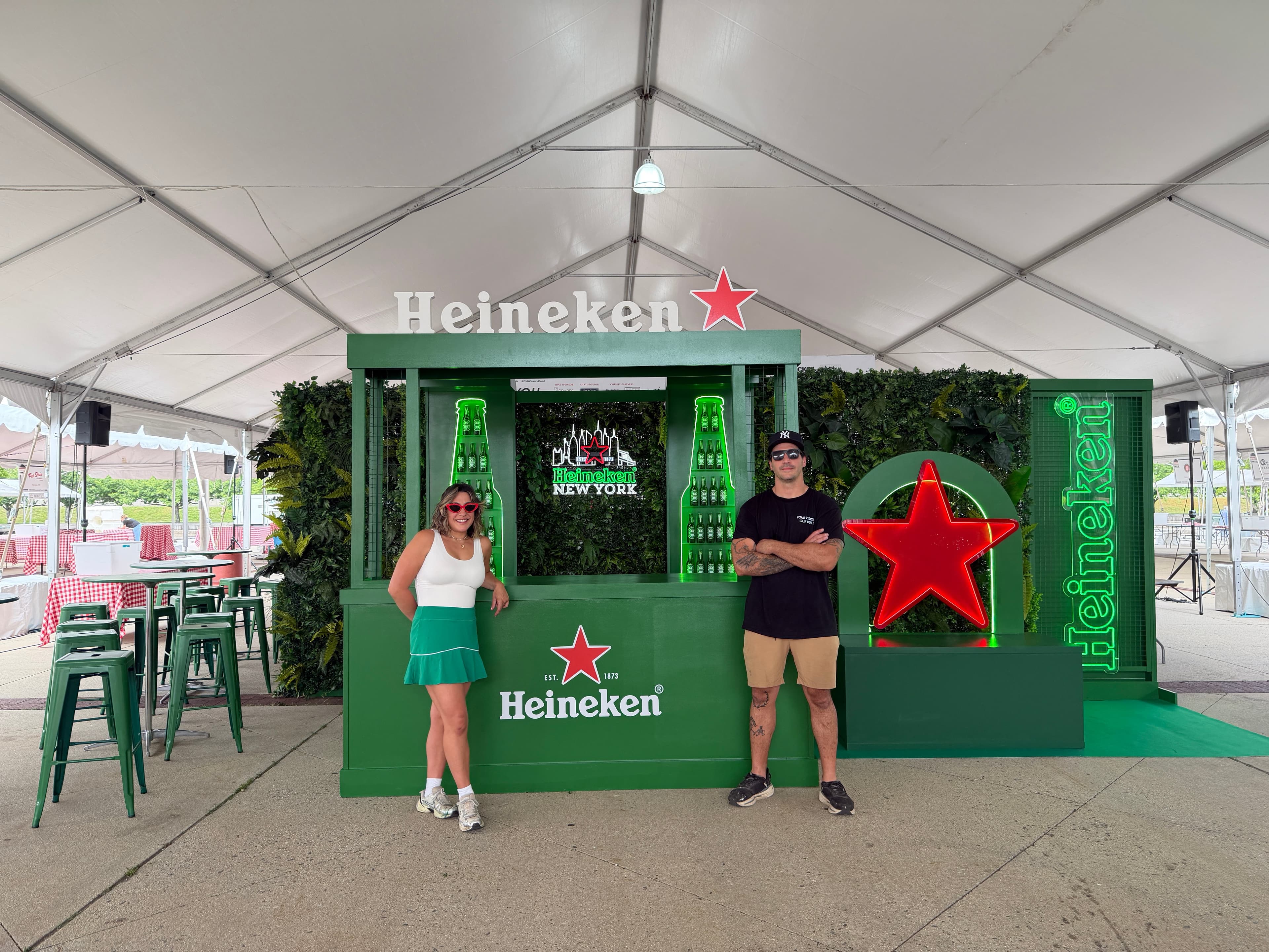 Heineken New York branded bar build with neon signage and illuminated red star under an event tent